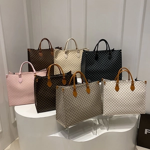 Sacs cabas vintage à monogramme en sept couleurs sur un podium blanc moderne