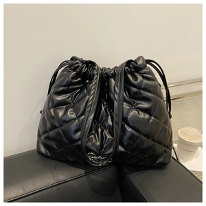 Close-up of black quilted bucket bag with silver chain detail and drawstring closure