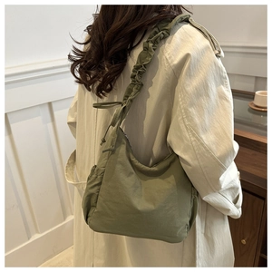 Detail view of olive green nylon tote with ruched strap and stylish drawstring elements