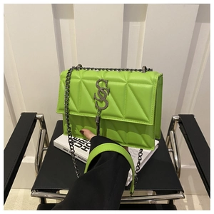Détail du sac bandoulière matelassé vert fluo avec une boucle métallique en forme de S chic