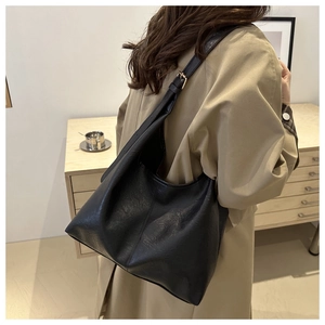 Detail of adjustable strap with gold buckle on black leather hobo shoulder bag