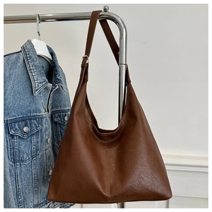 Detail of dark brown PU leather tote with lychee texture and adjustable buckle strap
