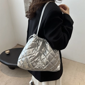 Silver quilted metallic tote bag with metal bow and drawstring detail for women