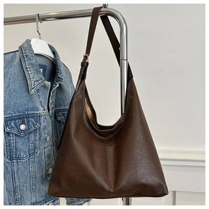 Deep brown tote bag with lychee texture and shoulder strap hanging on a metal rack