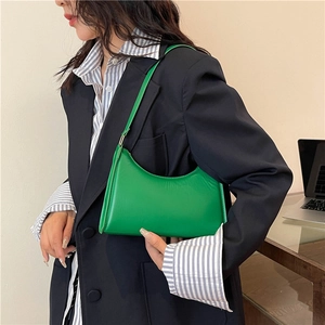 Modern emerald green hobo bag with minimalist design shown on a professional model