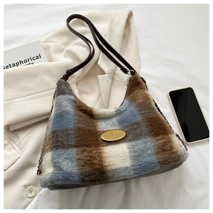 Détail du sac hobo avec texture en laine à carreaux et bandoulière en cuir marron