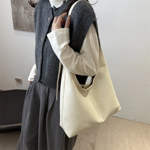 Minimalist beige tote bag with vintage wrinkled texture shown on a female model