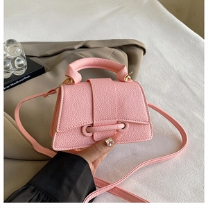 Detail of light pink lychee texture leather handbag with gold ring hardware and drawstring