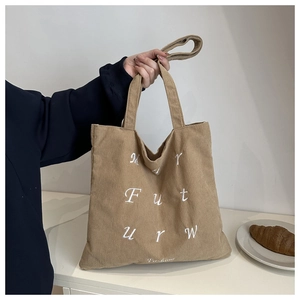 Close-up of the My Future embroidery and corduroy texture on the khaki tote bag