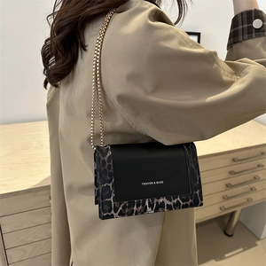 Retro leopard print crossbody bag with gold chain strap worn with a khaki trench coat