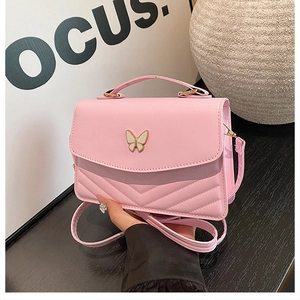 Détail du sac bandoulière rose en PU avec fermoir papillon et coutures en V