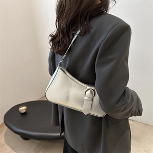 Minimalist silver metallic shoulder bag with buckle detail shown from a side-angle view