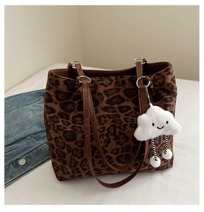 Macro detail of leopard print tote bag with brown faux leather strap and cloud charm