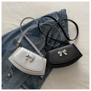 Detail view of stylish bow decor on silver and black minimalist crescent crossbody bags
