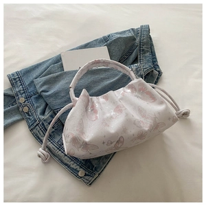 Detail of cream pleated cloud bag featuring pink butterfly prints and thick rope handle
