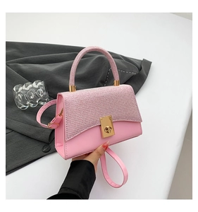 Detail of pink patchwork crossbody bag with glitter texture and gold rotating buckle lock