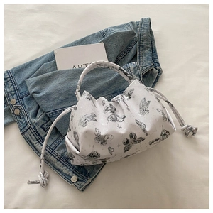 Detail of white butterfly print handbag with drawstring pleats on textured leather