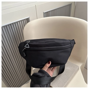 Détail du sac bandoulière en nylon noir avec doubles fermetures et tirette triangle