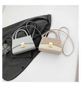 Detail of trendy color-block crossbody bag with glitter flap and metallic buckle closure