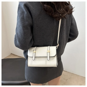 Vue arrière du mannequin portant un sac carré blanc minimaliste avec boucle dorée