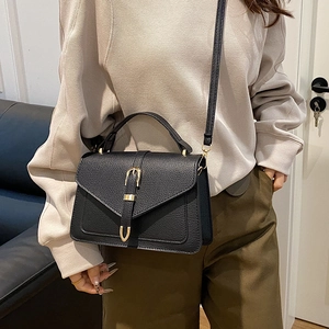 Classic black pebbled leather crossbody bag with elegant gold horseshoe buckle hardware