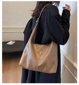 Detail shot of khaki PU leather tote bag with vintage texture on a model shoulder