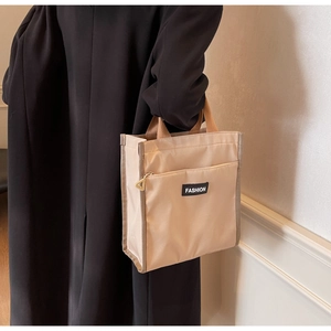 Détail du sac cabas kaki minimaliste avec étiquette mode et curseur de fermeture éclair