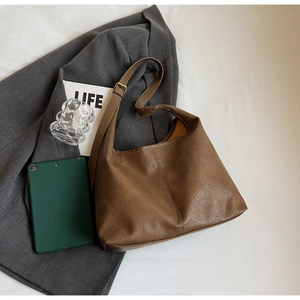 Detail of vintage brown leather hobo bag with adjustable strap and soft texture
