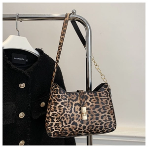 Detail der Leopardenmuster-Tasche mit goldenem Metallschloss und Kettenriemen