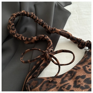 Detail of leopard print shoulder bag with scrunchie strap and decorative bow knot
