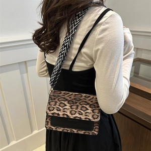 Chic leopard print crossbody bag with wide geometric strap shown on model for autumn