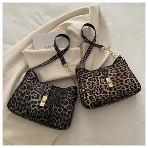 Detail von Schultertaschen mit Leopardenmuster, Goldkette und Schnalle auf hellem Blazer