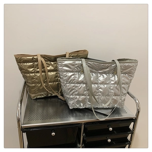 Detailed macro view of silver and champagne gold quilted tote bags with metallic finish