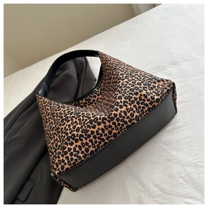 Close-up of leopard print canvas hobo bag with black leather base and shoulder strap