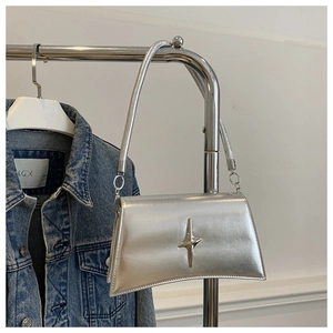 Détail du sac à bandoulière argenté avec boucle métallique en forme d'étoile polie