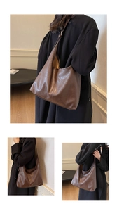 Detail of vintage brown leather tote bag showing rich pleated texture and large hobo style