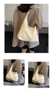 Detail of a large cream hobo bag showing soft lychee texture and comfortable shoulder fit