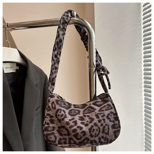 Detailed close-up of leopard print faux fur hobo bag with unique pleated shoulder strap design