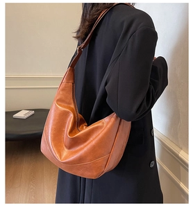 Detail of dark brown leather hobo bag showing a spacious design and wide shoulder strap