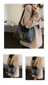 Detail of a large black Hobo bag featuring premium pebble grain texture and shoulder strap