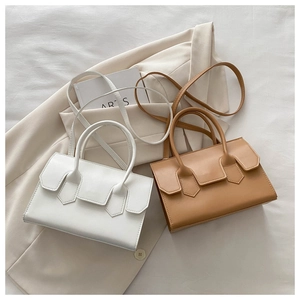Minimalist small flap handbags in white and brown leather on a professional setup