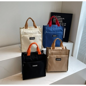 Vue détaillée de sacs cabas en toile de différentes couleurs sur un présentoir blanc