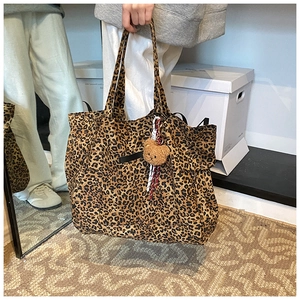 Detailaufnahme der großen Leopard-Tragetasche mit einem braunen Plüschbär-Anhänger