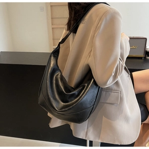 Detailed side view of a black hobo bag in soft synthetic leather with a half-moon shape
