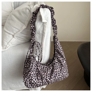 Close-up of leopard print shoulder bag with ruched handle and side drawstring detail