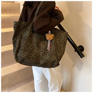 Große Shopper-Tasche mit Leopardenmuster und kleinem Plüschbären im Alltagsszenario