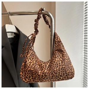 Detail of leopard print hobo bag featuring fashionable ruched shoulder strap and zipper