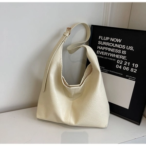 Detail of cream leather hobo bag with natural grain texture and adjustable strap