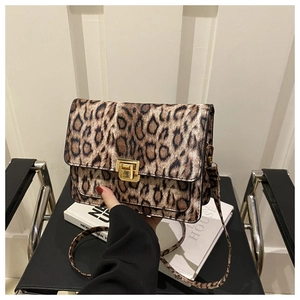 Close-up of leopard print crossbody bag featuring a gold square metal lock and flap