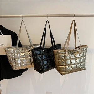 Quilted down cotton tote bags in silver, black, and gold colors on hangers